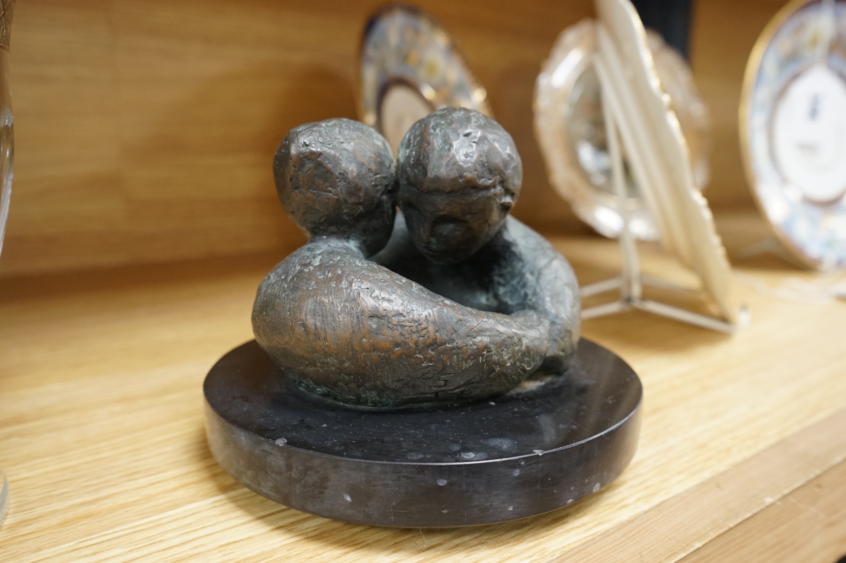 A contemporary bronze revolving sculpture of an embracing couple, unsigned, 16cm in diameter